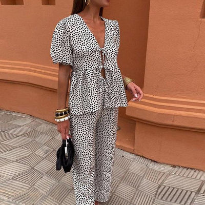 Tweedelige dames set met top met pofmouwen en striksluiting en wijde broek met hoge taille