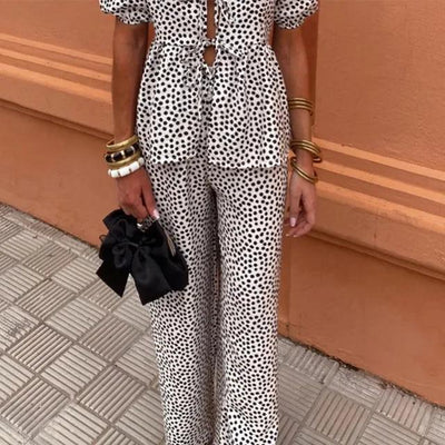 Tweedelige dames set met top met pofmouwen en striksluiting en wijde broek met hoge taille